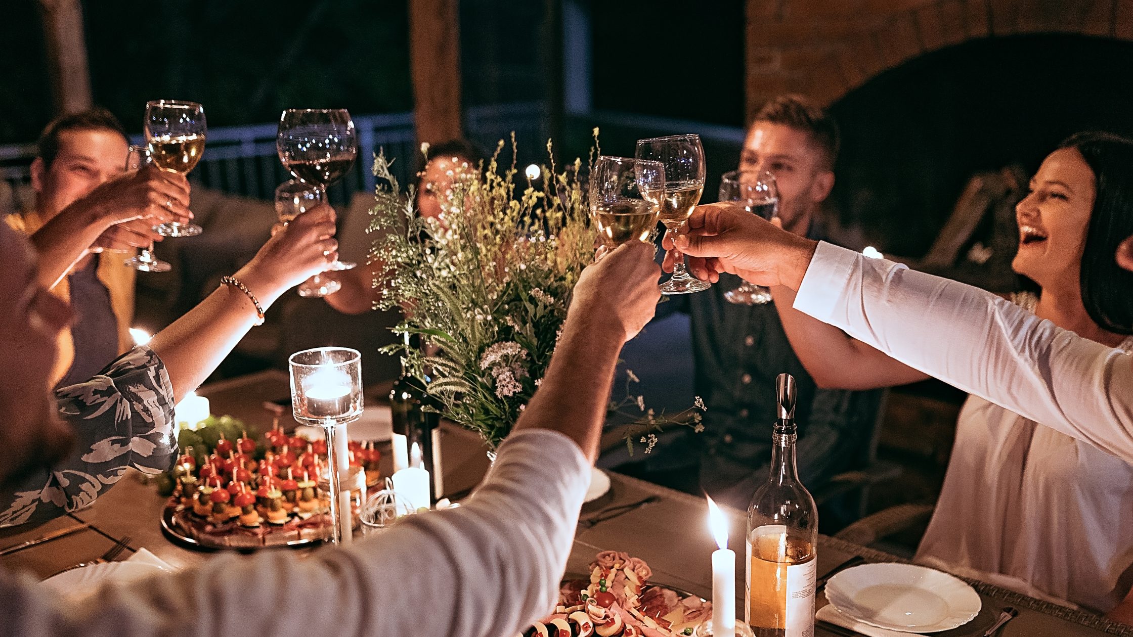 Friends toasting with wine at a dinner party